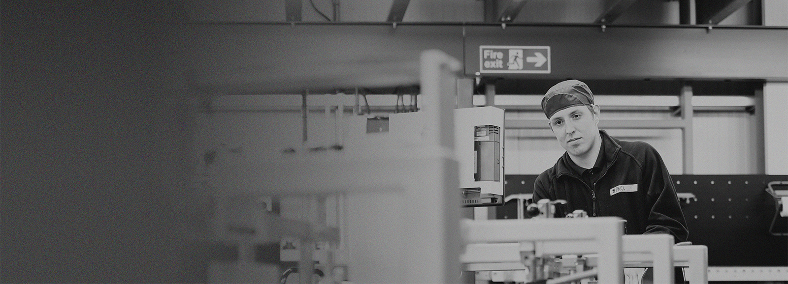 Production worker in factory manning a printing machine